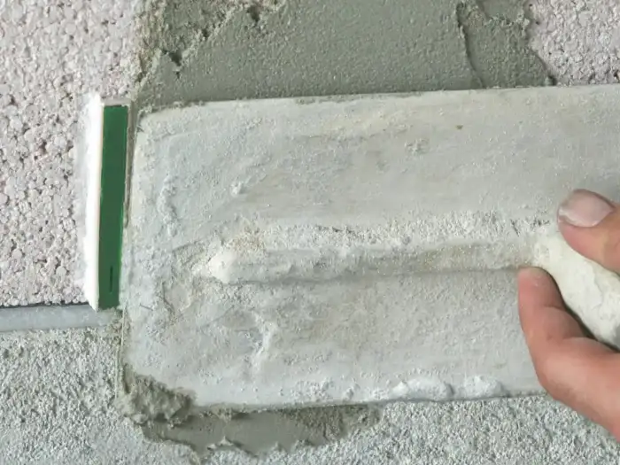 Weep vent being installed with rendering applied around it.